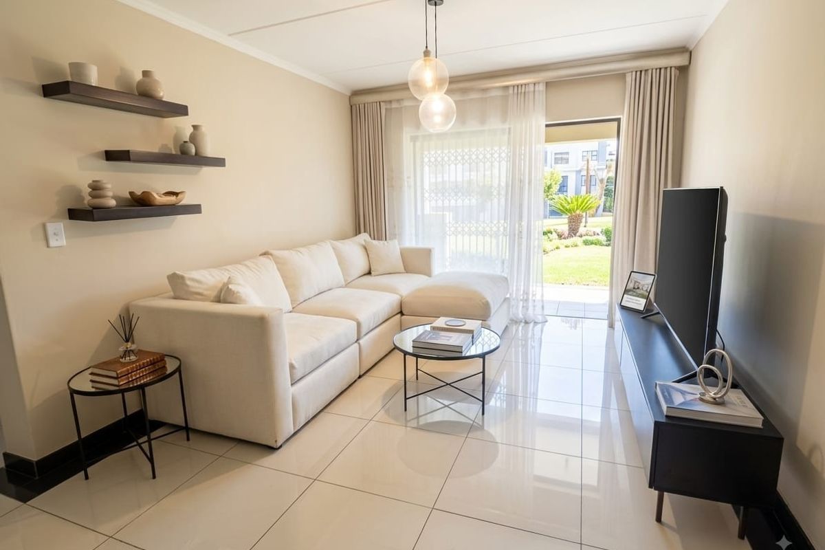 Modern living room featuring polished porcelain floor tiles, neutral wall tones, and a sliding glass door providing direct access to the garden area.