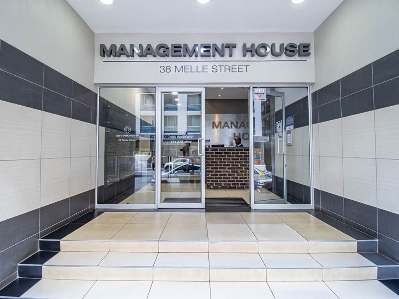 Main entrance to Management House at 38 Melle Street, featuring glass doors, tiled steps, and a professional reception area.