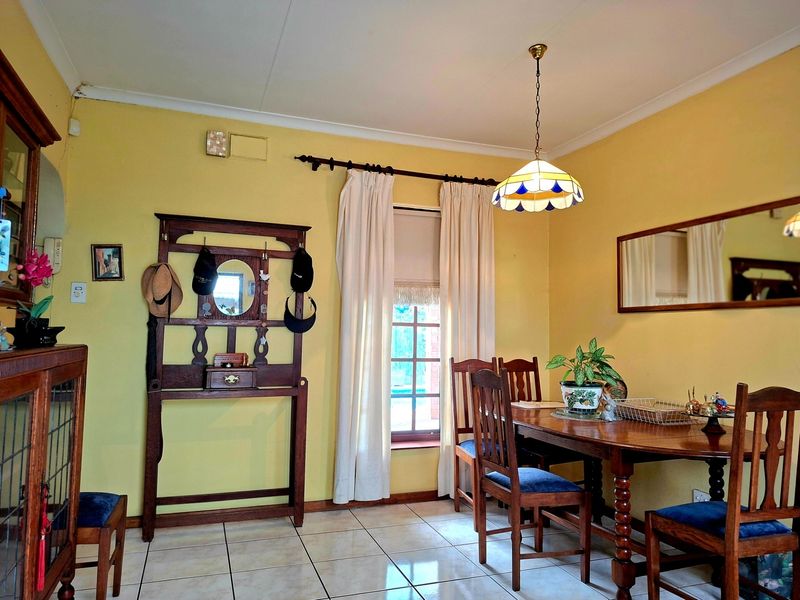 A dining room featuring tiled flooring, coved ceilings, and a central pendant light fixture, providing a functional space for meals.
