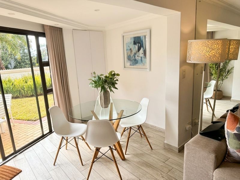 Bright dining area featuring tiled flooring, recessed lighting, a built-in cupboard, and a large sliding glass door providing access to the outdoor patio.