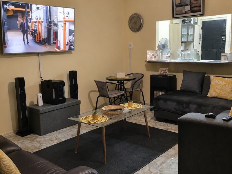 A living room featuring tiled flooring and a convenient pass-through window with a breakfast bar connecting to the adjacent space.