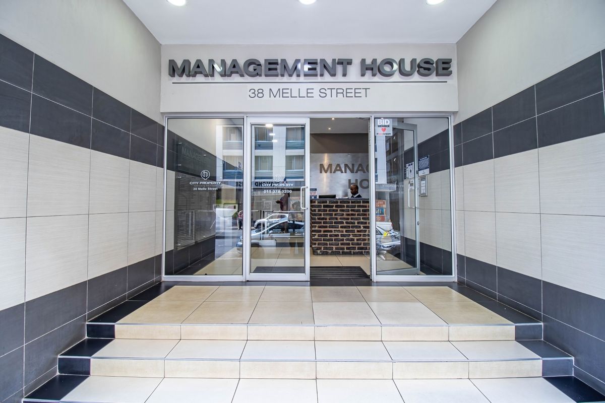 Main entrance to Management House at 38 Melle Street, featuring glass doors, tiled steps, and a professional reception area.