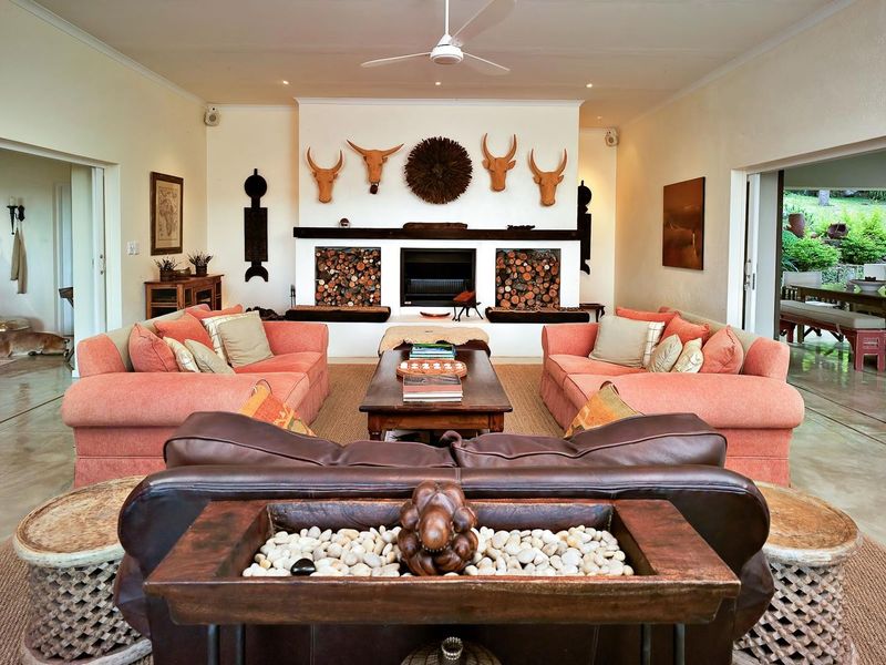 Spacious living room featuring a prominent built-in fireplace with integrated log storage, polished concrete floors, and a ceiling fan.