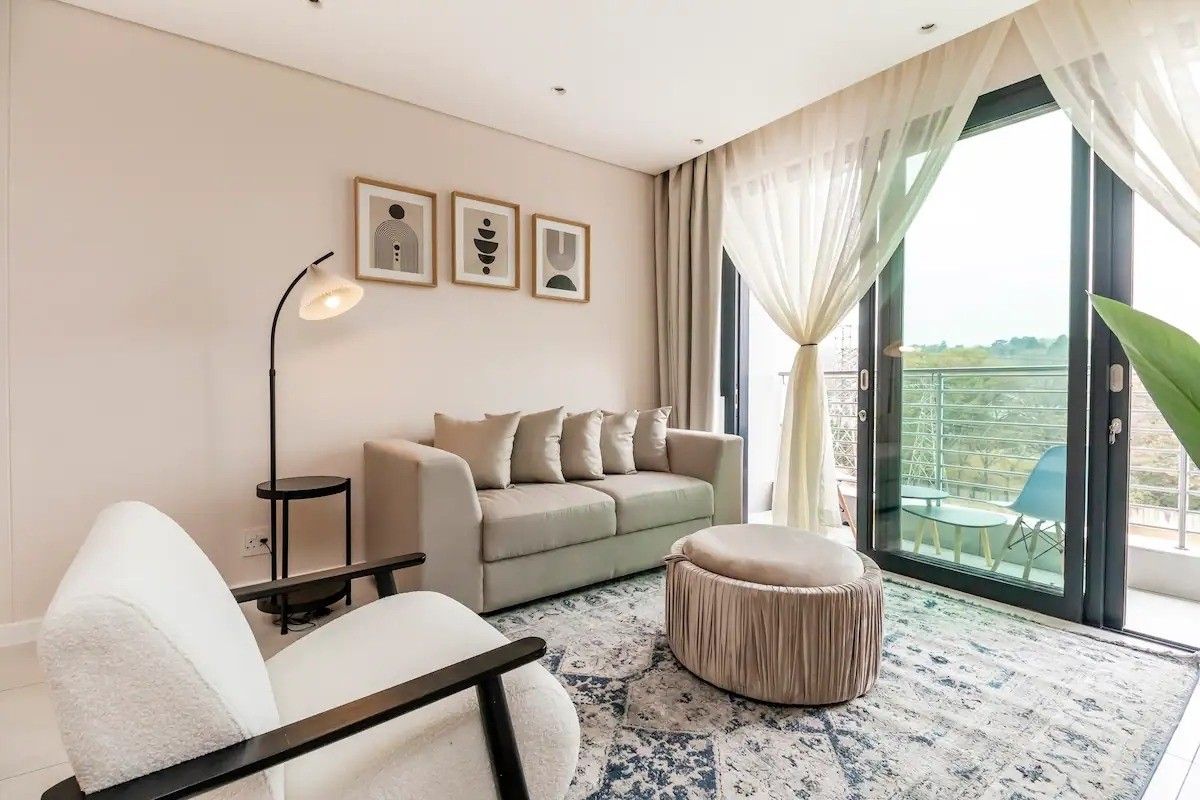 A bright and modern living room featuring large sliding glass doors that provide natural light and access to an outdoor balcony area.