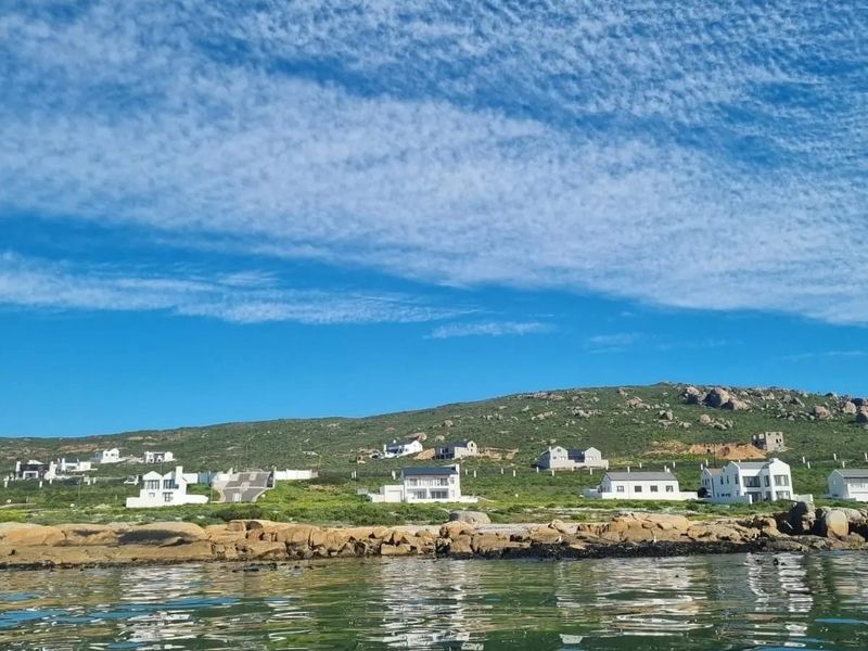 A scenic view of the coastal landscape and rocky shoreline, showcasing the surrounding residential area and natural environment.
