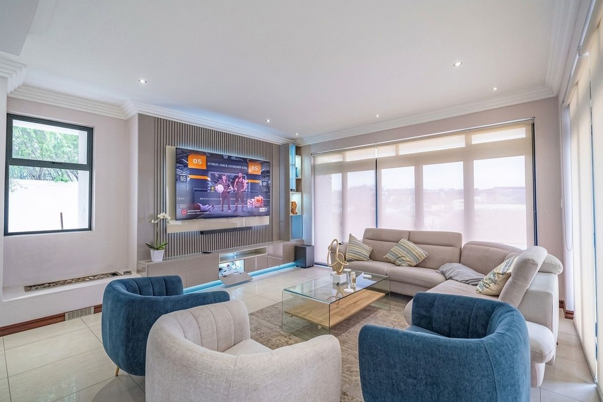 Modern living room featuring a custom built-in media unit with slatted wall paneling, recessed lighting, and large windows with roller blinds.