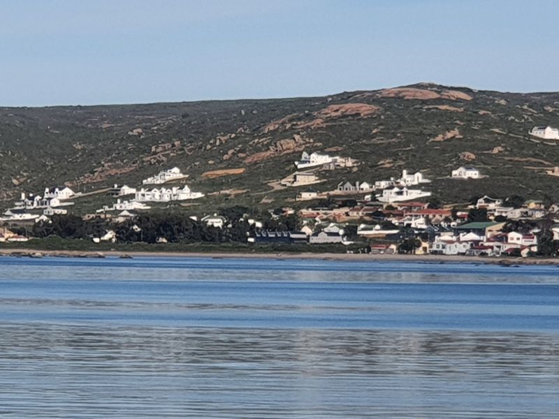 A scenic coastal view overlooking the bay towards the hillside residential development.