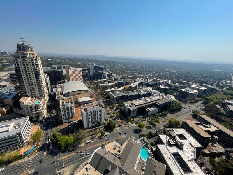 An elevated aerial view showcasing the surrounding urban landscape, city infrastructure, and high-rise buildings from a high vantage point.