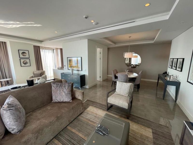 Spacious open-plan living and dining area featuring high-quality tiled flooring, recessed ceiling lighting, and a modern tray ceiling design.