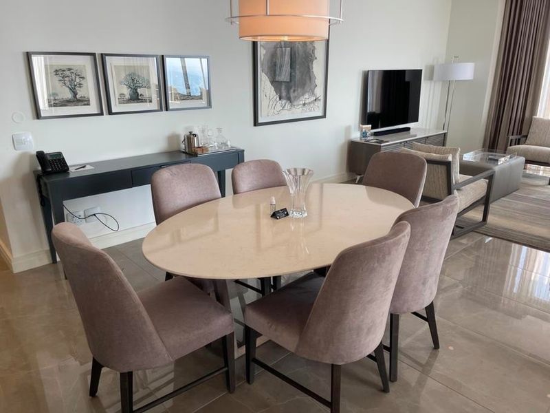 A well-maintained dining area featuring polished tiled flooring and a modern pendant light fixture, creating a bright and inviting space for meals.