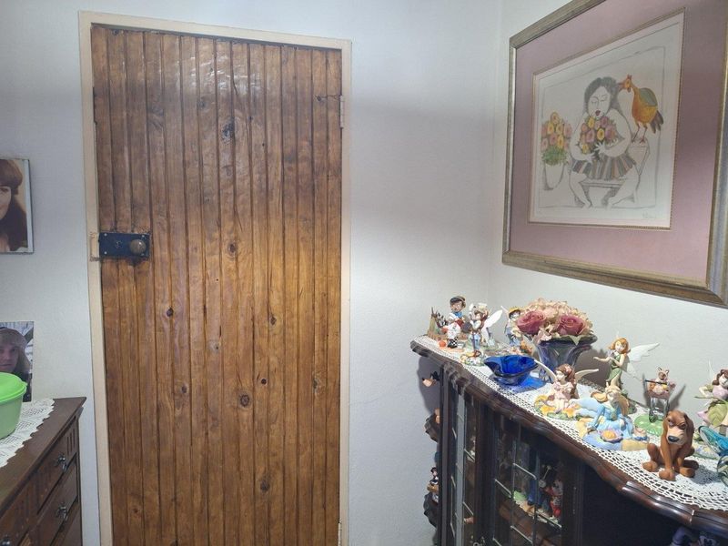 A view of a hallway featuring a traditional vertical-plank timber door.
