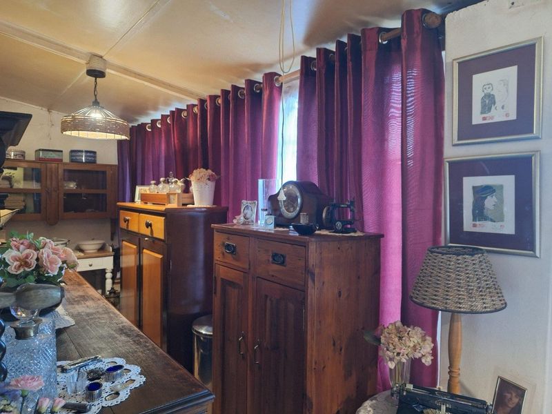 A living area featuring a pendant light fixture and window treatments, showcasing a traditional interior style with fixed architectural elements.