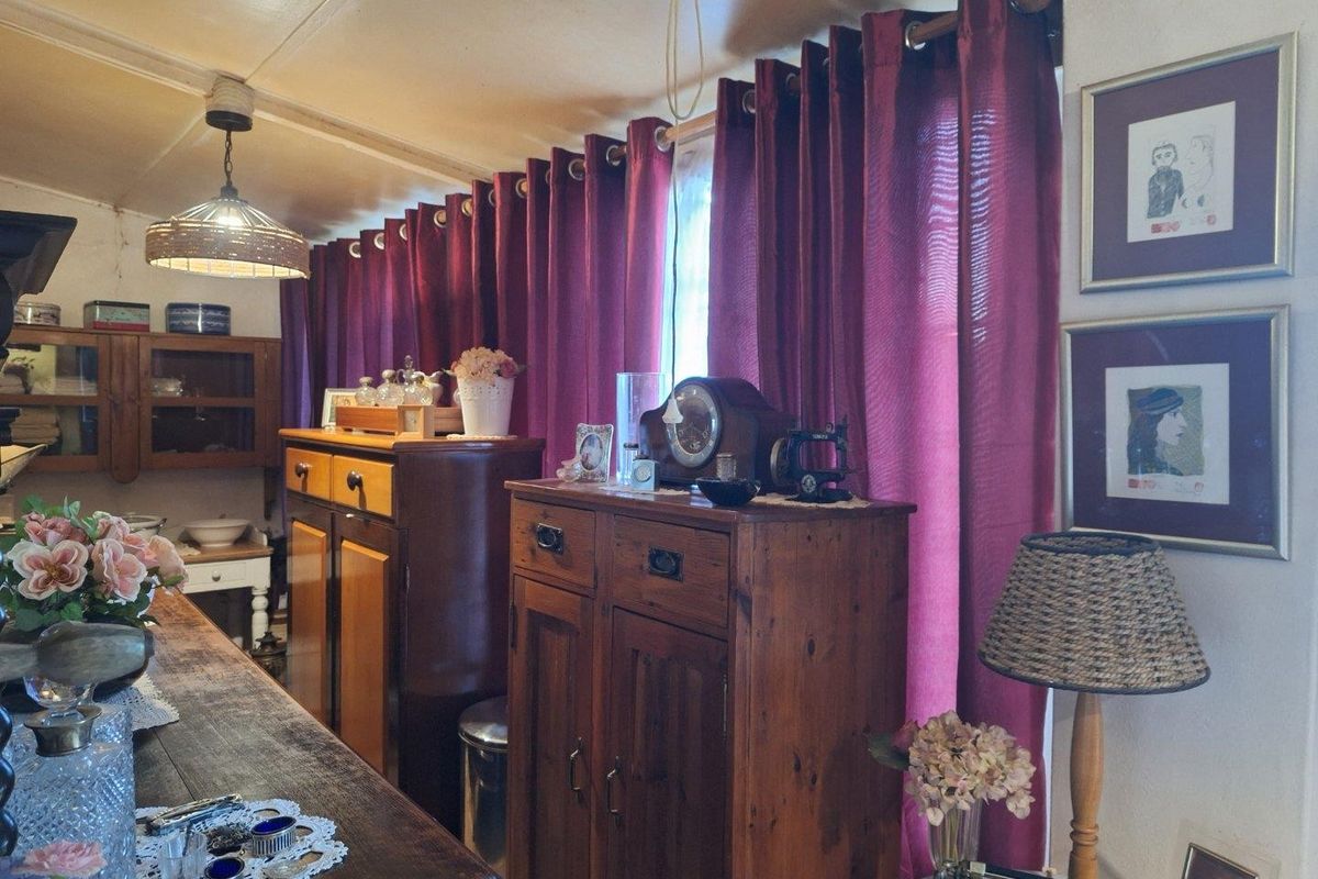 A living area featuring a pendant light fixture and window treatments, showcasing a traditional interior style with fixed architectural elements.