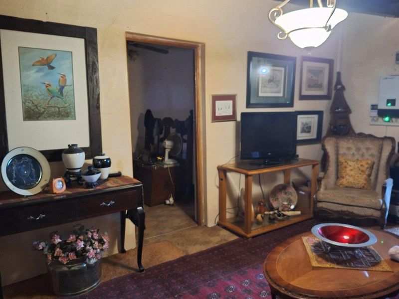 A living room area featuring visible wall plaster damage and dated finishes, offering potential for renovation and modernization.
