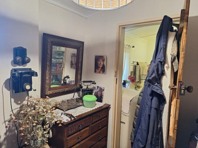 A small hallway area featuring a doorway leading into an adjacent room, with neutral wall finishes and a central ceiling light fixture.