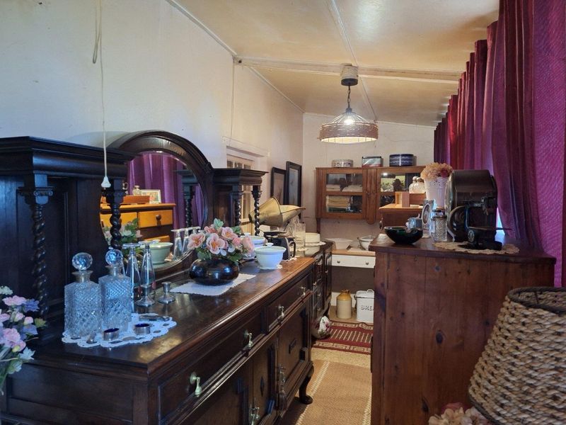 A living area featuring traditional wooden cabinetry and a pendant light fixture, offering a classic aesthetic with potential for modern updates.