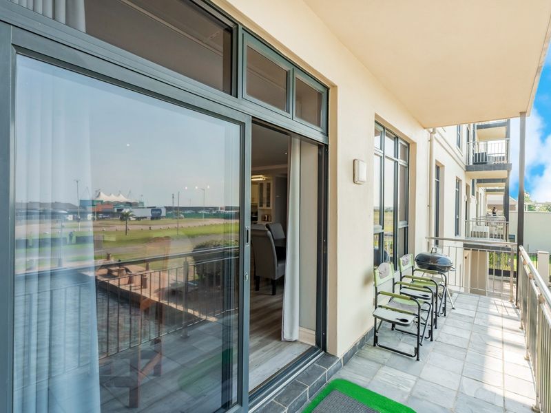A covered balcony featuring tiled flooring, metal balustrades, and large sliding glass doors providing access to the interior living space.