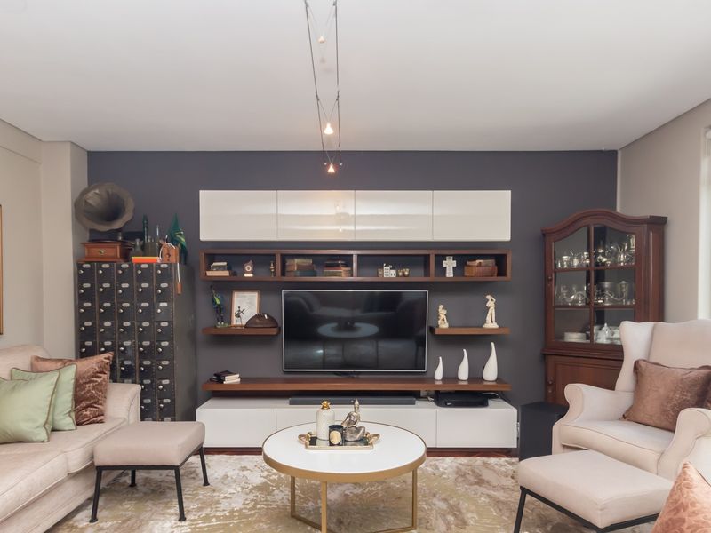 A well-appointed living room featuring a modern built-in media console with integrated shelving and a dark grey accent wall.