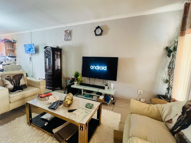 A living room featuring tiled flooring and neutral wall finishes, providing a functional space for relaxation and entertainment.