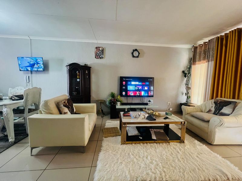 A comfortable living room featuring tiled flooring and neutral wall finishes, providing a functional space for relaxation and entertainment.