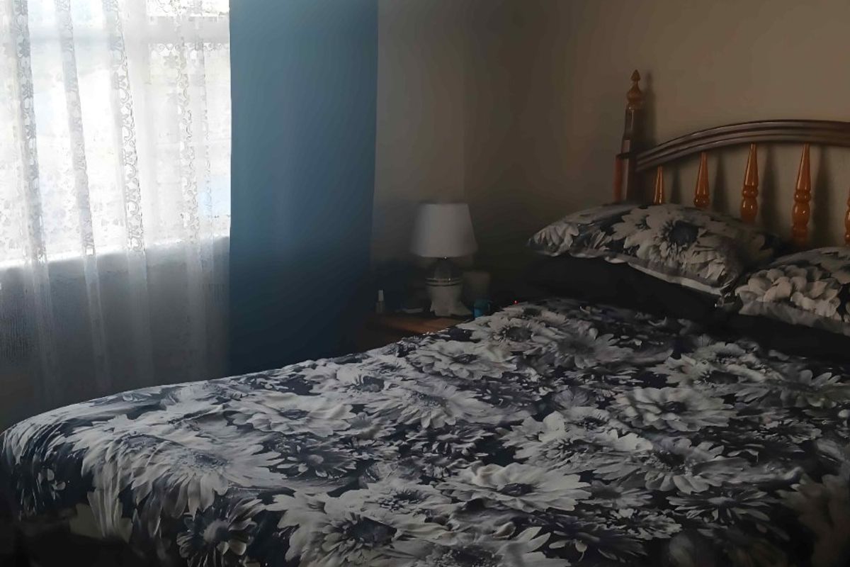 A bedroom featuring a window with curtains, providing natural light to the space.