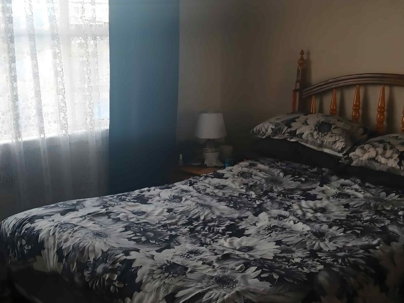 A bedroom featuring a window with curtains, providing natural light to the space.