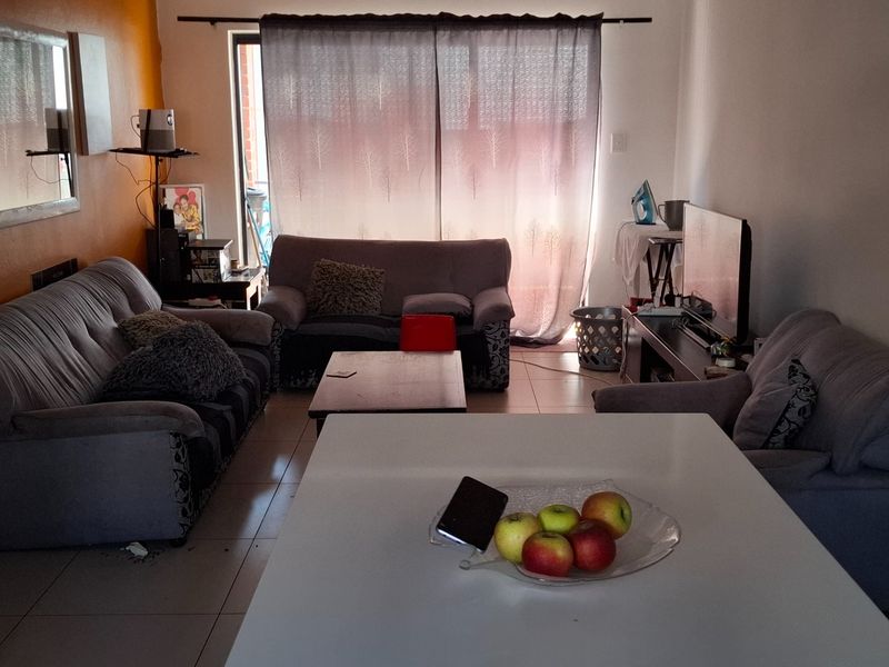 Open plan living area featuring tiled flooring and a sliding glass door providing access to the exterior.