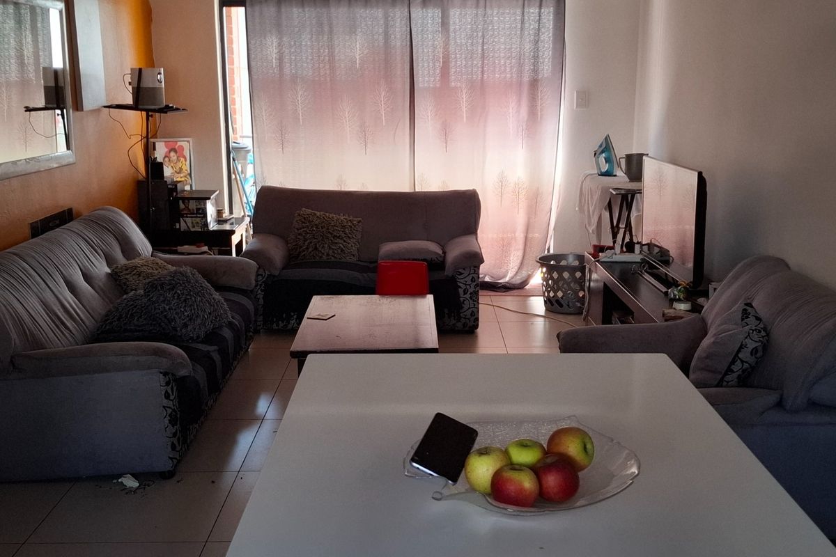Open plan living area featuring tiled flooring and a sliding glass door providing access to the exterior.
