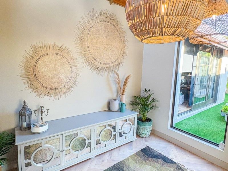 Bright living area featuring exposed timber rafter ceilings, herringbone timber flooring, and large sliding glass doors providing access to the outdoor space.
