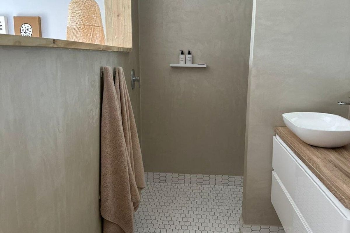Modern bathroom featuring a sleek vanity with a vessel sink, neutral plaster-style wall finishes, and patterned floor tiling.