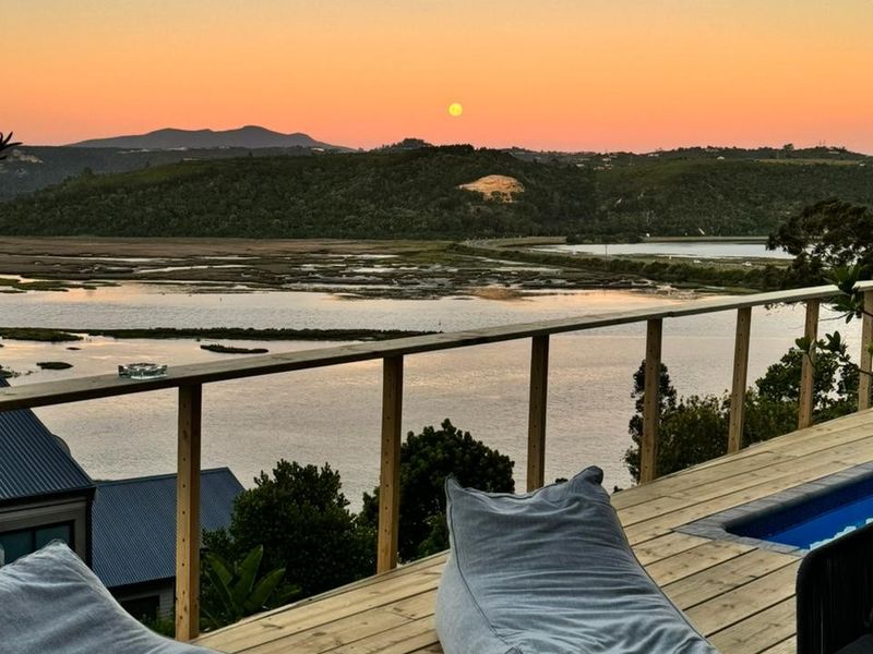 Elevated timber deck featuring a plunge pool and expansive views over the estuary and surrounding landscape at sunset.