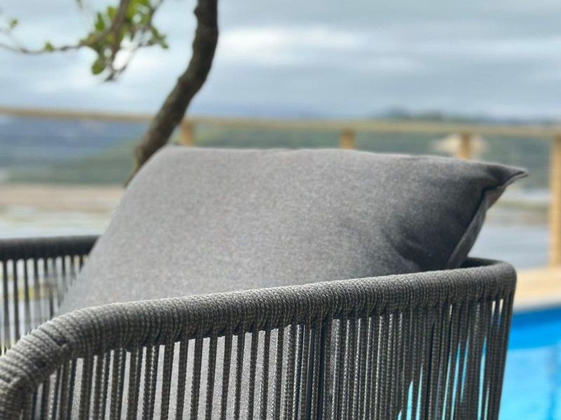Outdoor pool area featuring timber decking and a balustrade with scenic views.