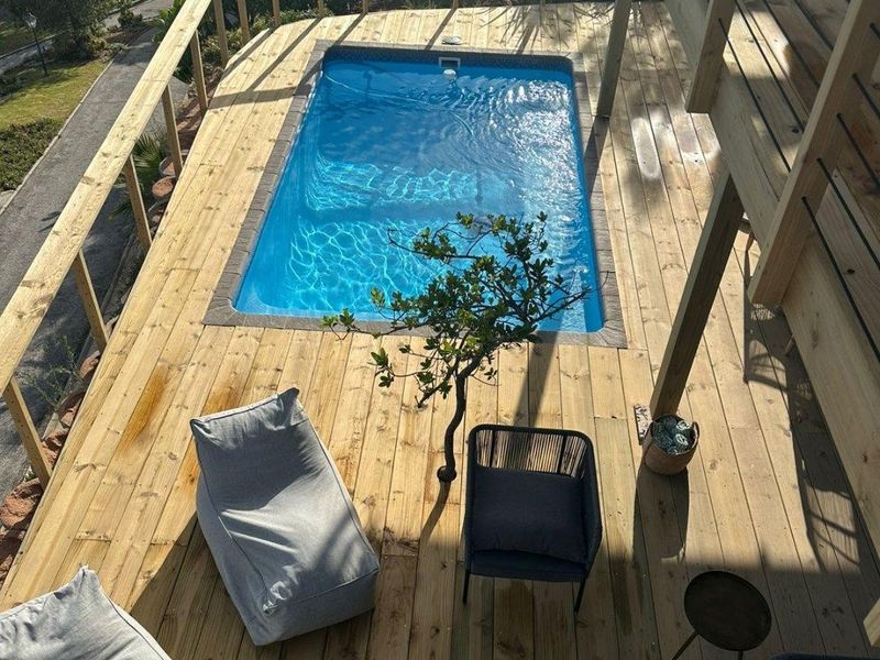 Elevated timber deck featuring a built-in swimming pool and wooden balustrade, offering an outdoor entertainment space.
