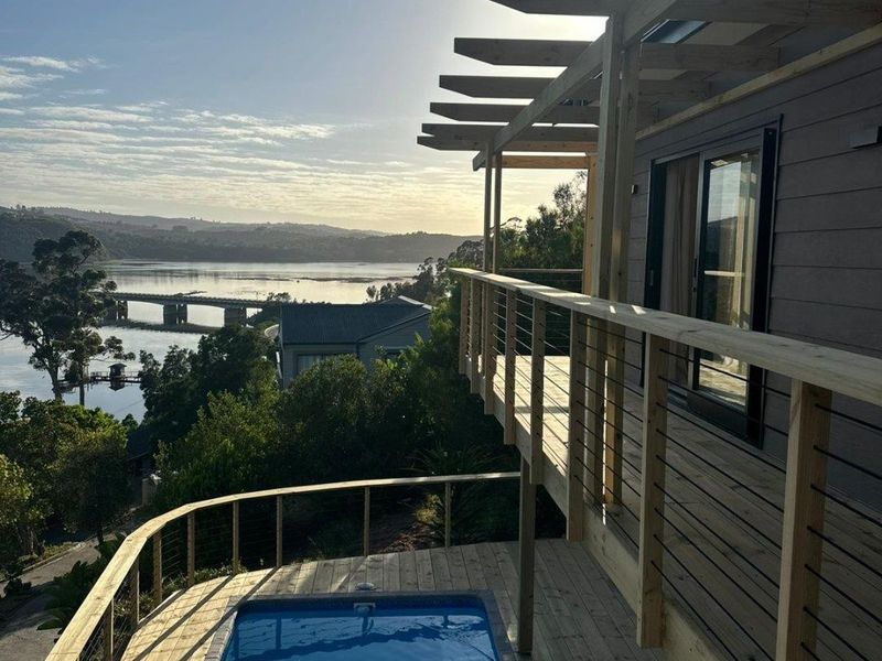 Elevated timber deck featuring a plunge pool, pergola structure, and expansive views over the water and surrounding landscape.