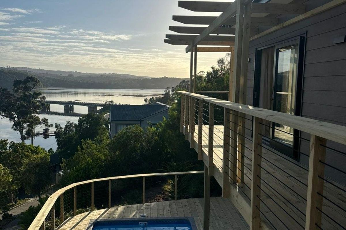 Elevated timber deck featuring a plunge pool, pergola structure, and expansive views over the water and surrounding landscape.