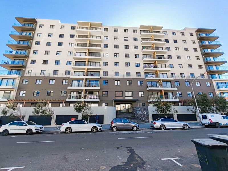 Street-level view of Chapel Towers apartment complex, featuring a modern multi-story facade with private balconies and secure ground-level parking access.