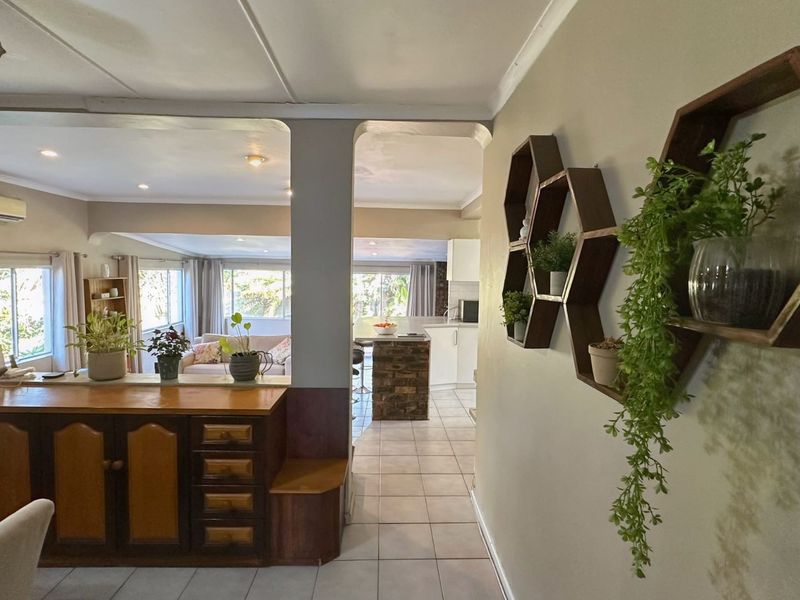 Open plan living and kitchen area featuring tiled flooring, built-in cabinetry, and a split-system air conditioner, creating a connected and functional living space.