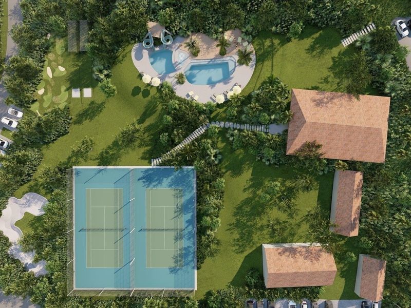 Aerial view of a property complex featuring tennis courts, a swimming pool, landscaped grounds, and multiple buildings with tiled roofs.