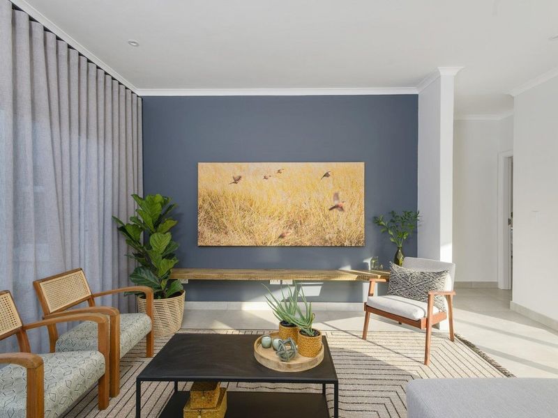 A bright and modern living room featuring a striking navy accent wall, a floating timber shelf, and large sliding glass doors with floor-to-ceiling curtains.