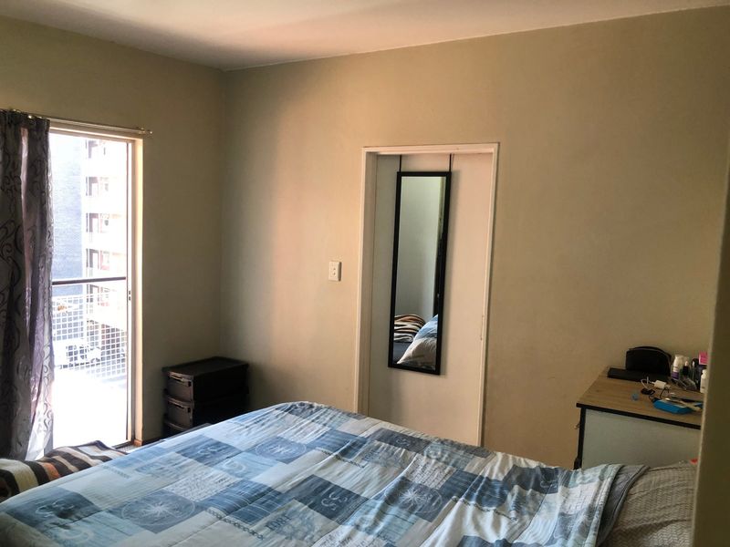 A bedroom featuring a sliding glass door that provides access to a balcony, allowing for natural light and ventilation.