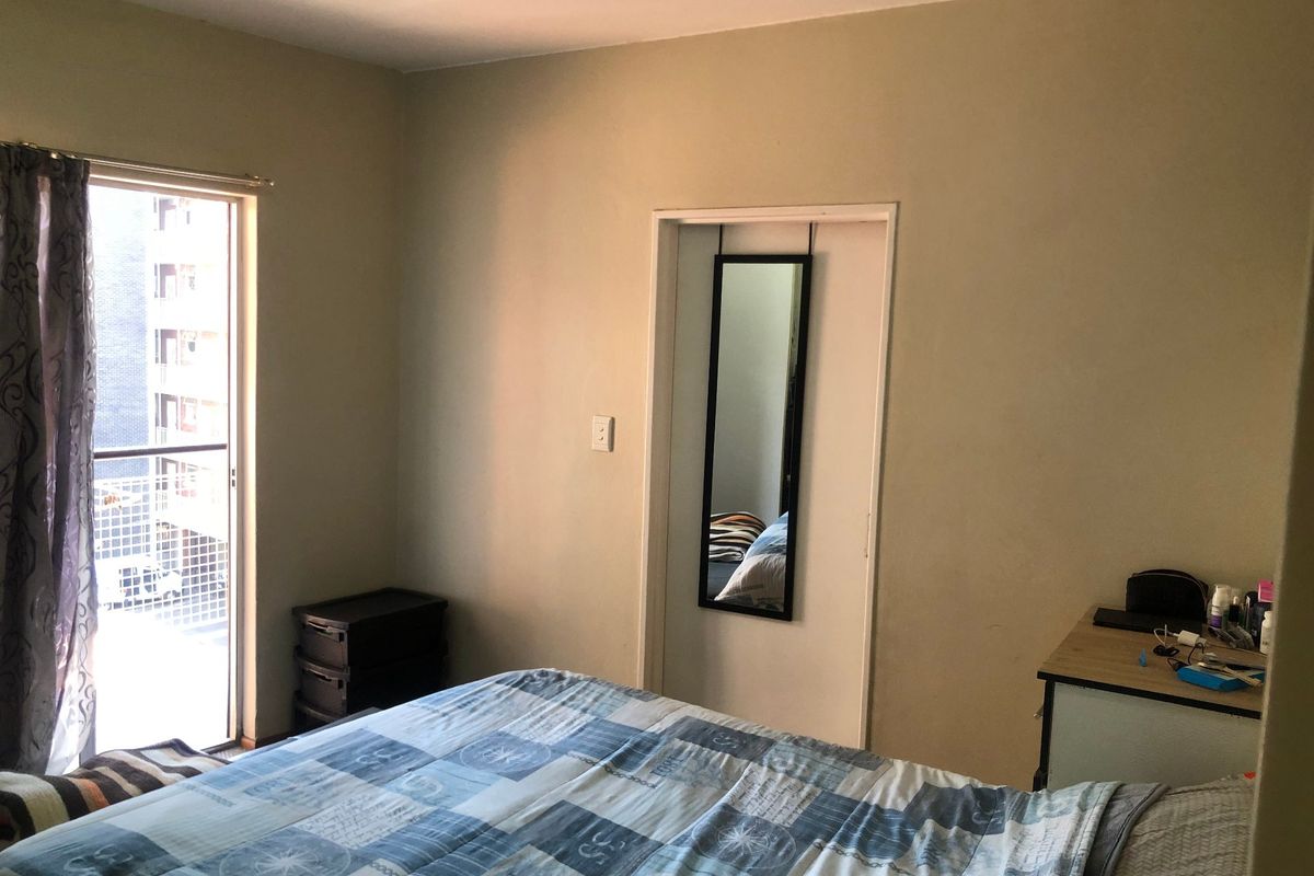 A bedroom featuring a sliding glass door that provides access to a balcony, allowing for natural light and ventilation.