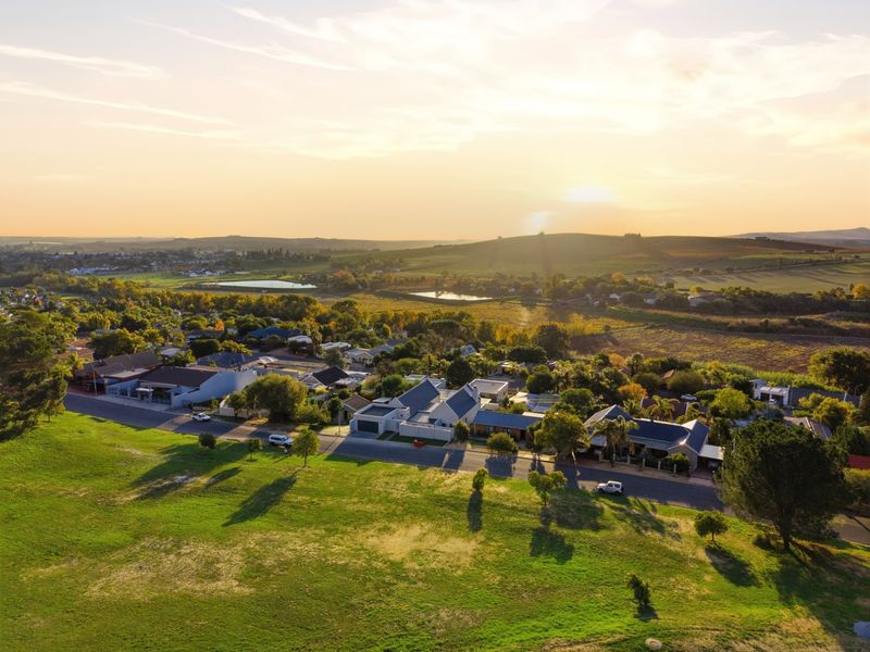 An elevated aerial view of the residential property and surrounding neighbourhood landscape at sunset.