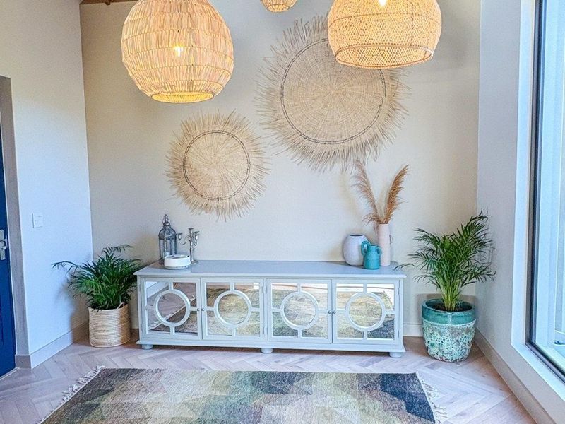 A bright and welcoming entrance hall featuring a high vaulted timber ceiling, elegant herringbone wood flooring, and modern recessed lighting.