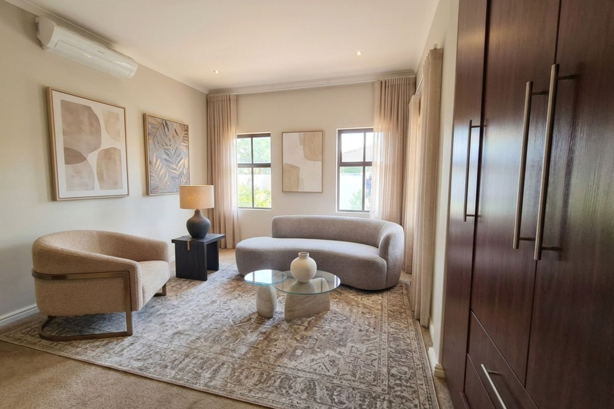 A well-appointed bedroom featuring neutral tones, built-in cabinetry, and a split-system air conditioning unit.