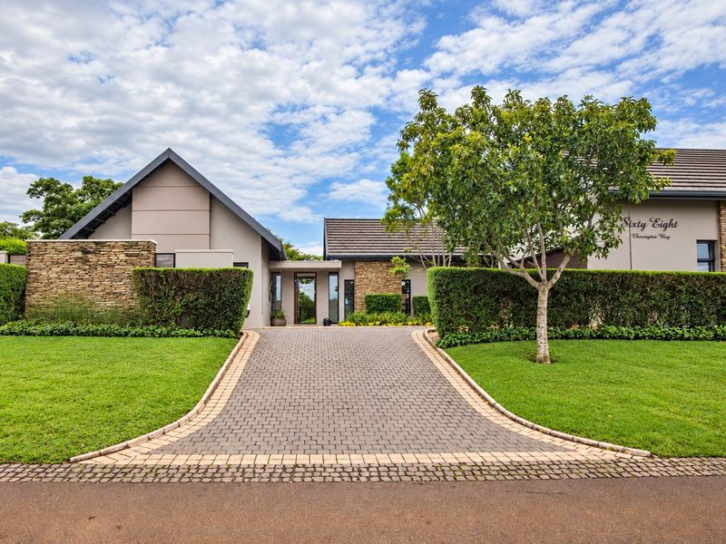 A well-maintained modern residence featuring stone cladding, a paved driveway, and manicured landscaping, presenting an attractive and welcoming front facade.