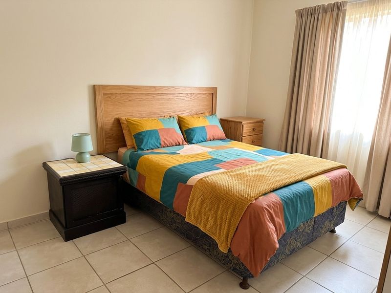 A bedroom featuring neutral walls and tiled flooring, providing a clean and functional space.