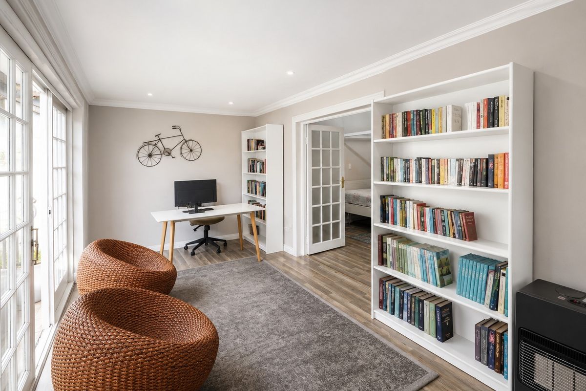 A bright living area featuring laminate flooring, built-in shelving, recessed lighting, and French doors providing access to the exterior.