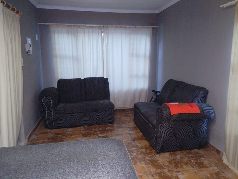 A living room area featuring tiled flooring and neutral wall finishes, providing a functional space ready for potential cosmetic updates.