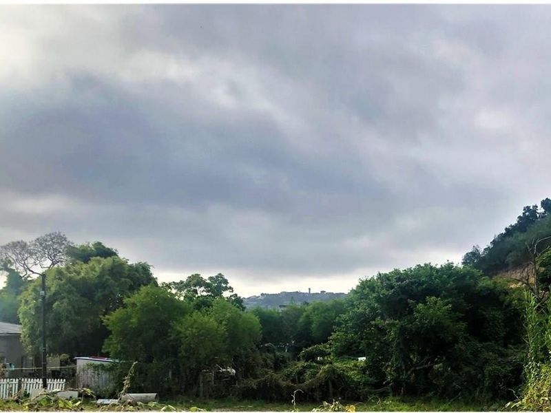 A view of the surrounding landscape and hillside under a cloudy sky.