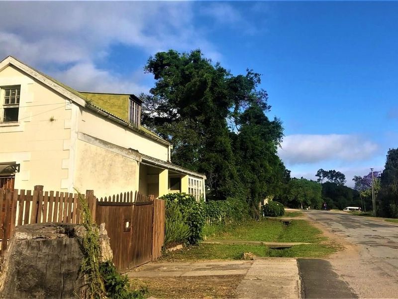 Street-level view of the property exterior, featuring a traditional pitched roof, dormer window, and timber boundary fencing.